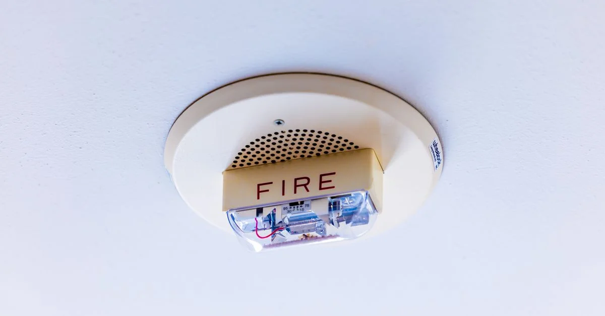 Gros plan sur un système d'alarme incendie fixé au plafond, assurant la sécurité d'un bâtiment.