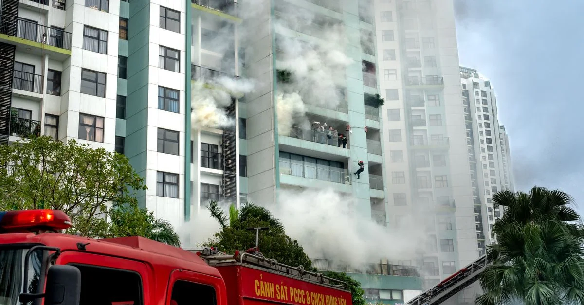 Les pompiers interviennent sur un incendie de bâtiment avec de la fumée et des véhicules d'urgence dans une zone urbaine.